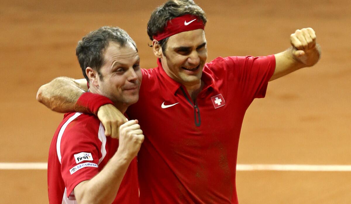 Swiss Coach Severin Luthi, left, and Roger Federer celebrate after Federer defeated France's Richard Gasquet in the Davis Cup final Sunday.