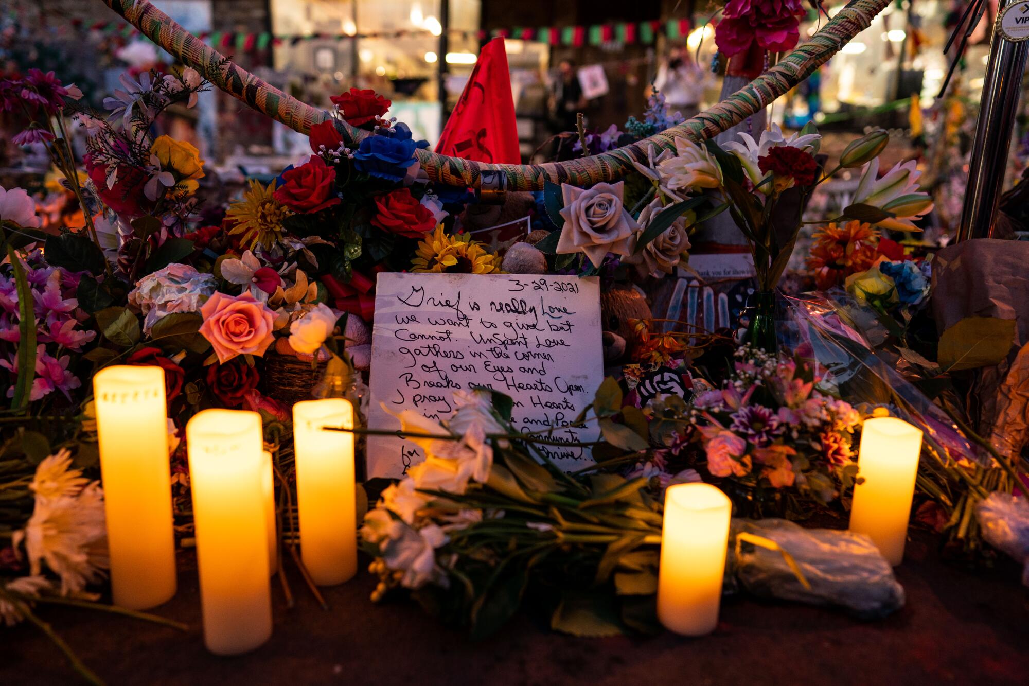 A note surrounded by candles and flowers reads in part, "Grief is really love we want to give but cannot."