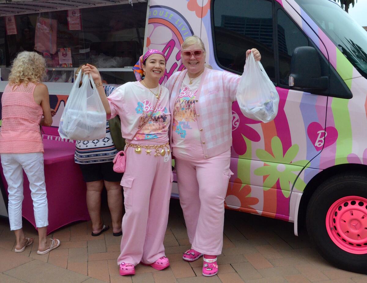 Decked out in Barbie attire, Stephanie Do and Gail Ireland show off their purchases.