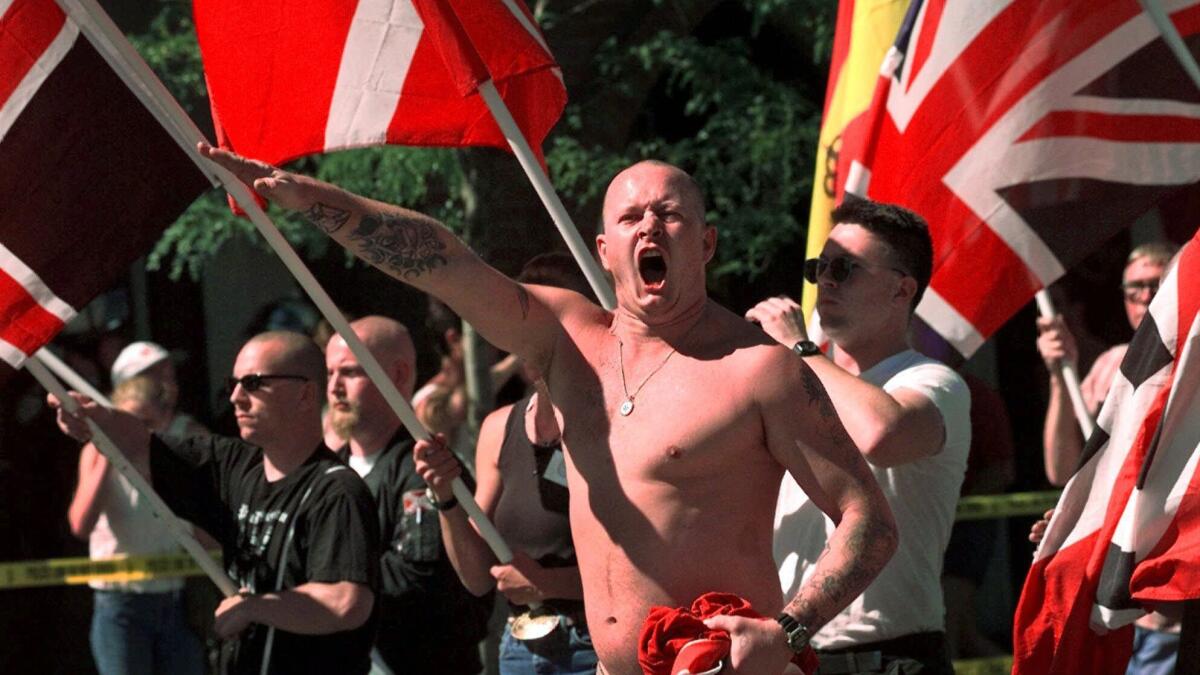 Karl Wolf raises his arm in a Nazi salute as he marches through the streets of Coeur d'Alene, Idaho, in July 1998.