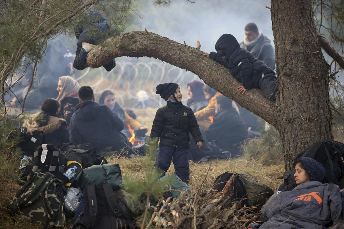 Migrants resting on the ground near the Belarus-Poland border