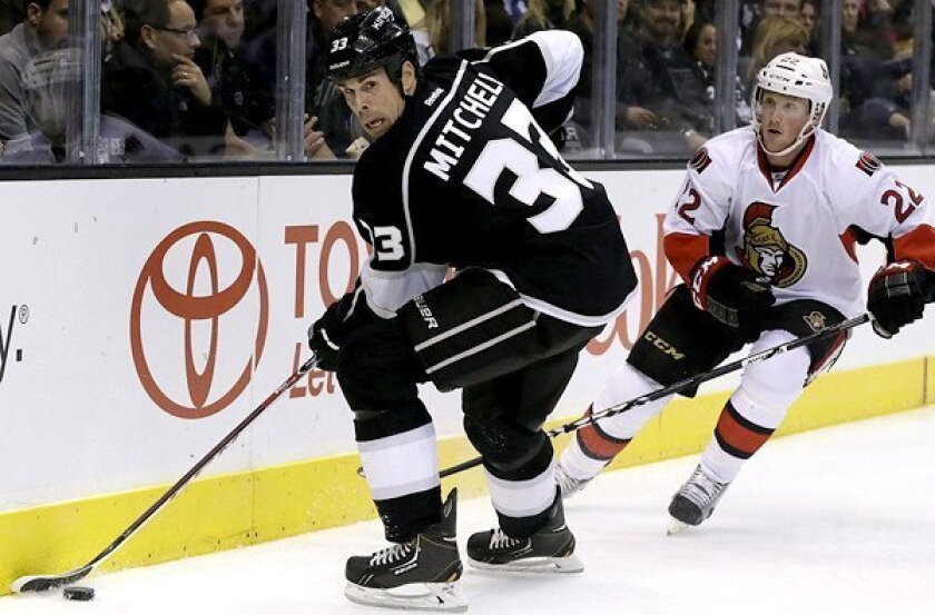 Kings defenseman Willie Mitchell controls the puck along the boards against Senators winger Erik Condra during a game earlier this season at Staples Center.