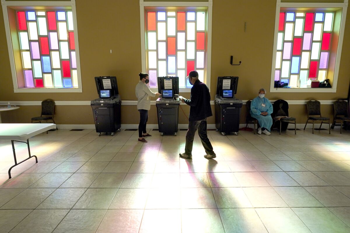 A man carries his ballot to the scanner as he votes Tuesday at a church in Nashville.
