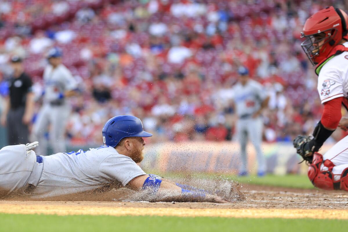 Dodgers' Justin Turner, left, scores a run ahead of the tag from the Reds' Aramis Garcia on June 21 in Cincinnati.