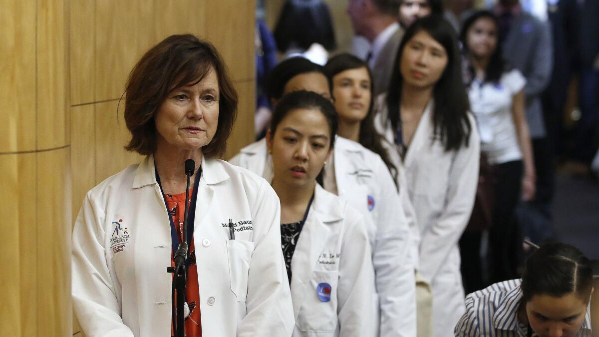 Doctors urge lawmakers to approve a bill giving state public health officials instead of local doctors the power to decide which children can skip their shots before attending school, at a hearing in Sacramento on April 24.