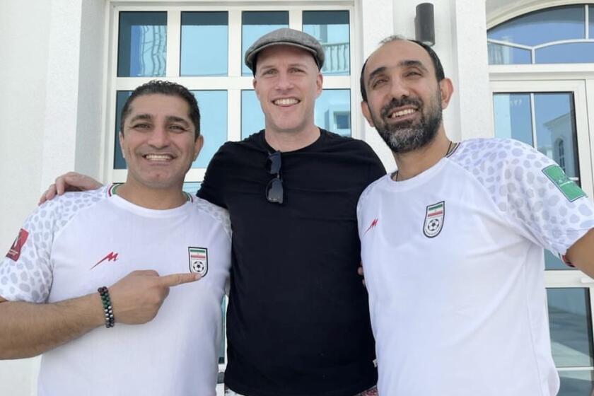 Soccer journalist Grant Wahl, center, poses with Iranian soccer fans 