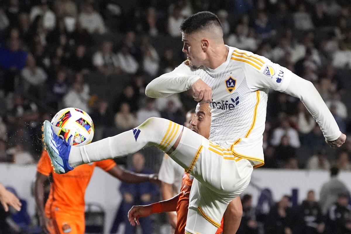 LA Galaxy forward Gabriel Pec, top, kicks the ball while under pressure from Houston Dynamo.