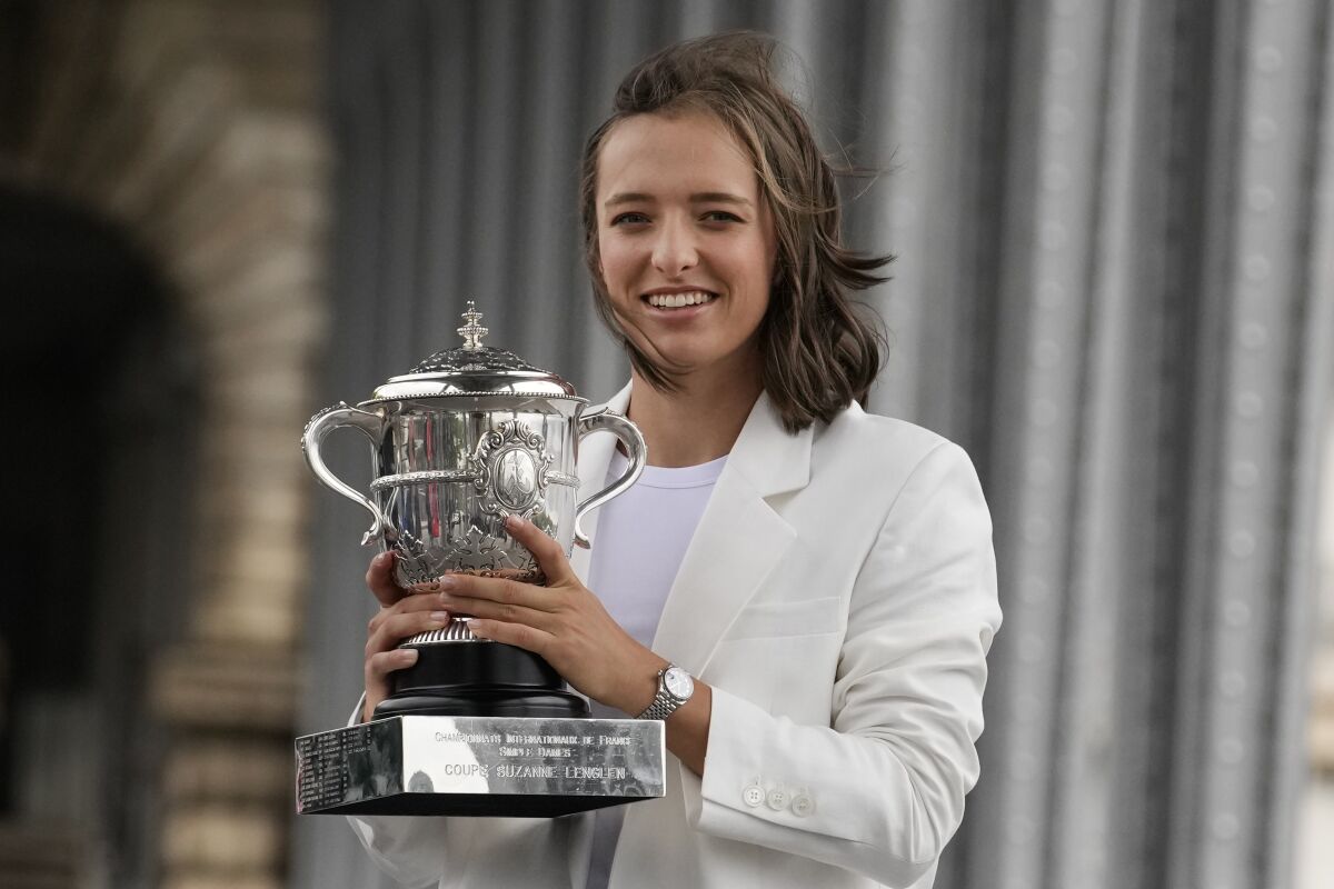 Poland's Iga Swiatek poses with the trophy in Paris, France, Sunday, June 5, 2022, after she won Saturday's women's final match at the French Open tennis tournament in Roland Garros stadium. (AP Photo/Christophe Ena)