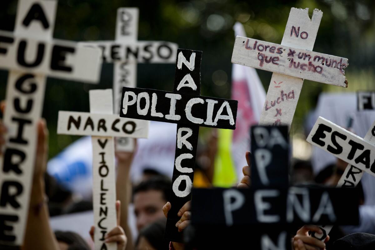 Demonstrators carry crosses inscribed with the words "Narco Cops" during a Nov. 5 protest in Mexico City against the disappearance of 43 students in the state of Guerrero.