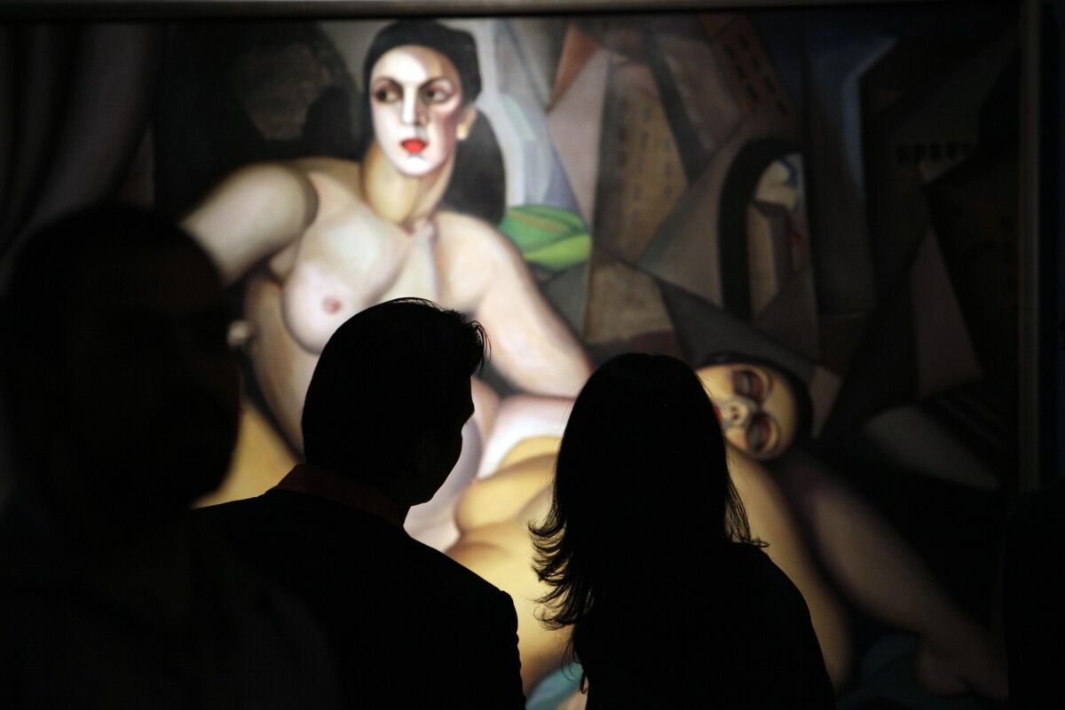 People look at a painting by Polish painter Tamara de Lempicka at the Bellas Artes Museum in Mexico City in 2009.