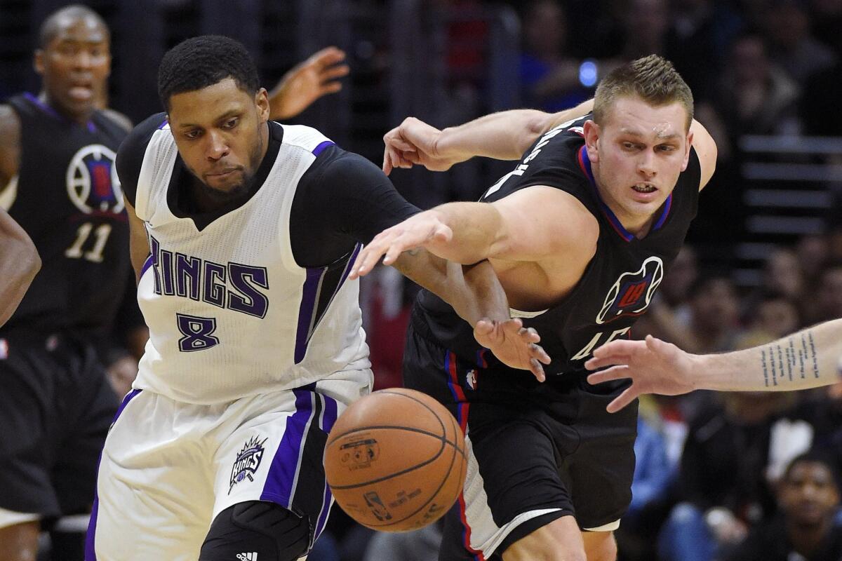 Clippers center Cole Aldrich, right, and Sacramento Kings forward Rudy Gay reach for the ball on Jan. 16.