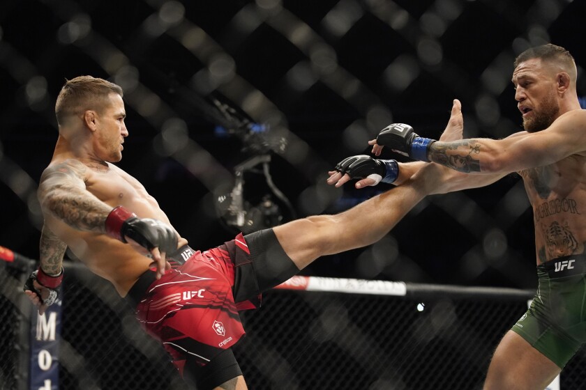 FILE - Dustin Poirier tries to kick Conor McGregor, right, during a UFC 264 lightweight mixed martial arts bout July 10, 2021, in Las Vegas. Charles Oliveira will defend his UFC lightweight title belt against Poirier in the main event of UFC 269 in Las Vegas on Saturday night, Dec. 11. (AP Photo/John Locher, File)