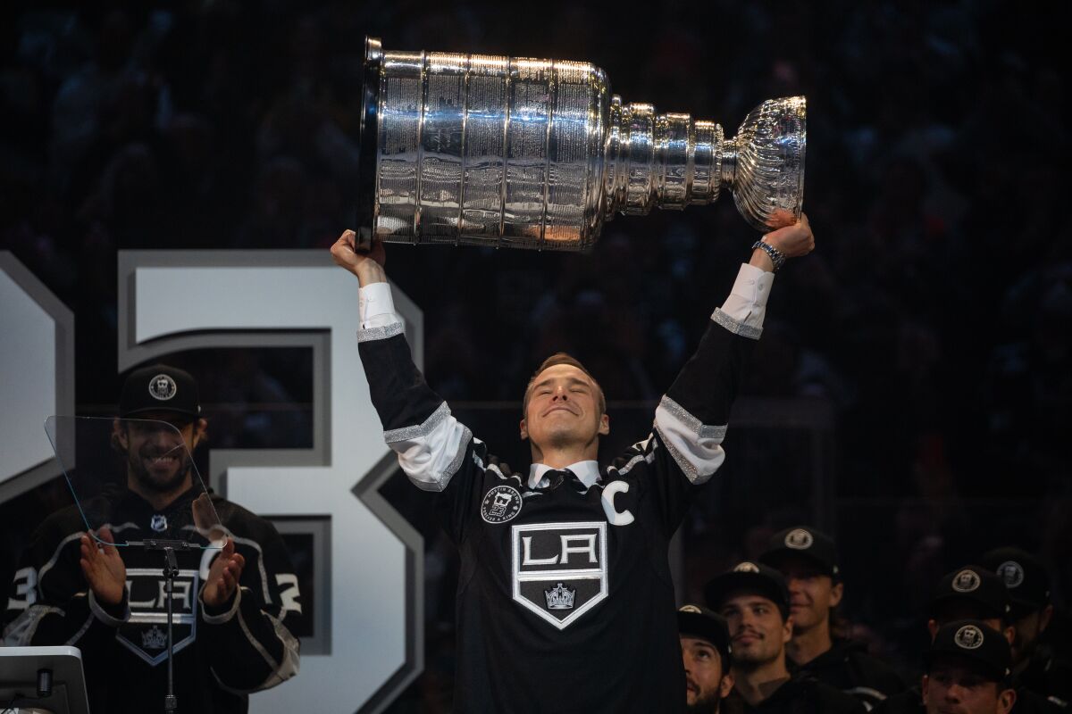 Former Kings captain Dustin Brown holds up the Stanley Cup during his number retirement ceremony.