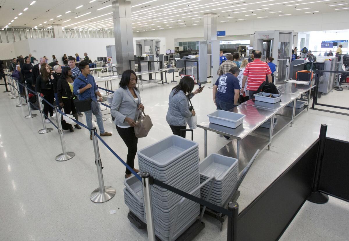 Viajeros se alinean en un puesto de control de seguridad en el Aeropuerto Internacional de Los Ángeles. La Administración de Seguridad del Transporte (TSA) probó brevemente un nuevo procedimiento que obligaba a los pasajeros a retirar el material de lectura de sus equipajes.