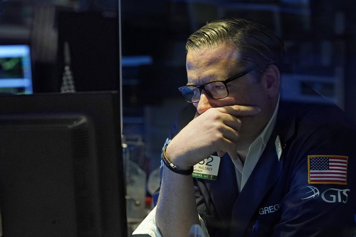 Specialist Gregg Maloney stares into a computer on the floor of the New York Stock Exchange