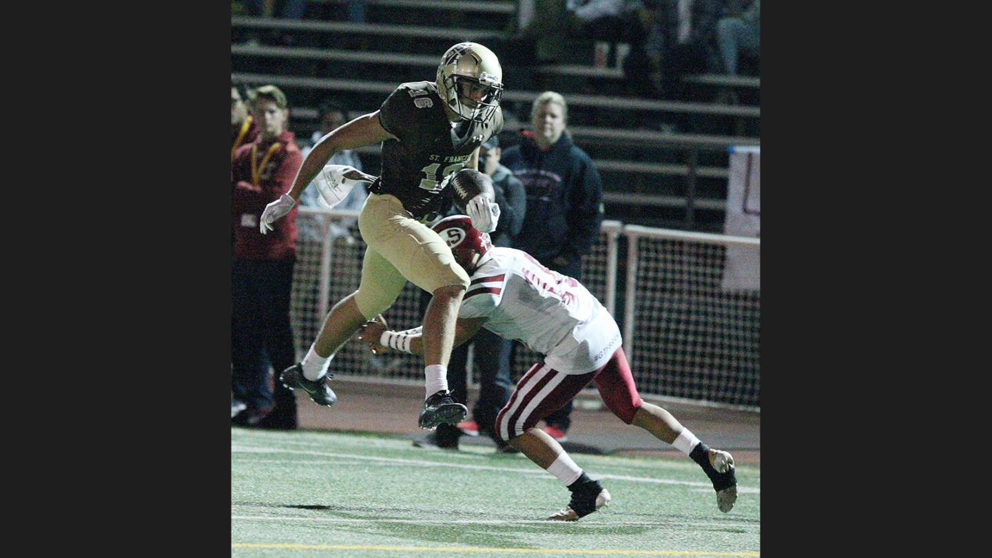 St. Francis' Greg Dulcich, after a long run, jumps to avoid being tackled by La Serna's Matthew Bustamante in a non-league football game at St. Francis High School in La Canada Flintridge on Friday, September 15, 2017.