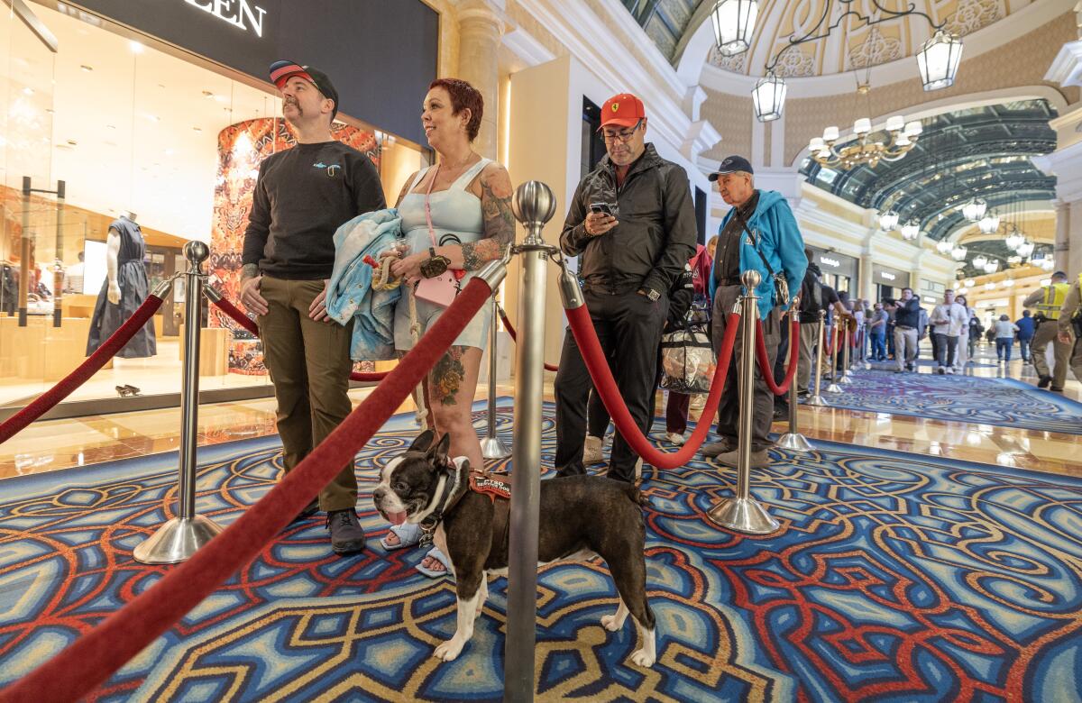 Troy and Mary Trimble, with their dog Moose, stand in line at the Bellagio in Las Vegas.