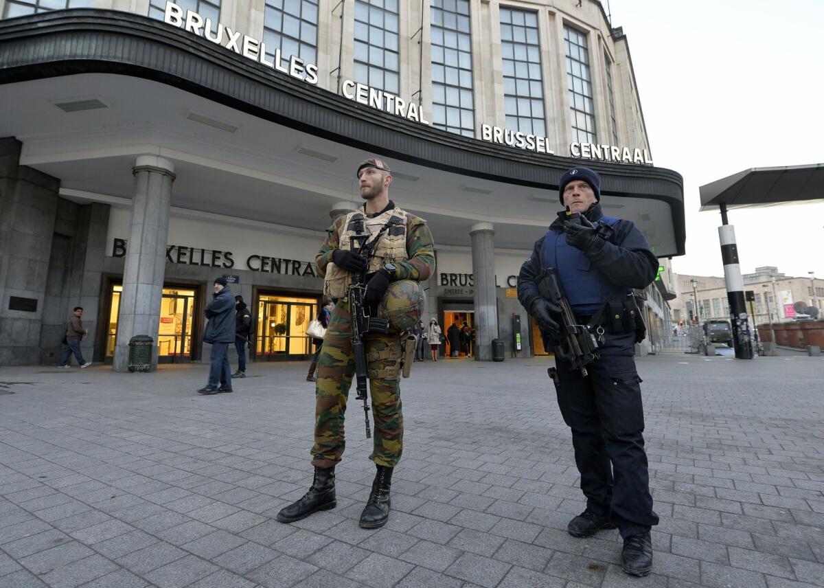 A Belgian policeman and a soldier stand guard outside the central station in Brussels on Monday.