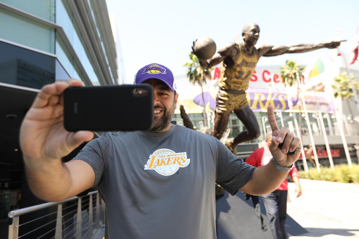 Abdel Assy takes a selfie in front of the Magic Johnson statue outside Staples Center on Monday.