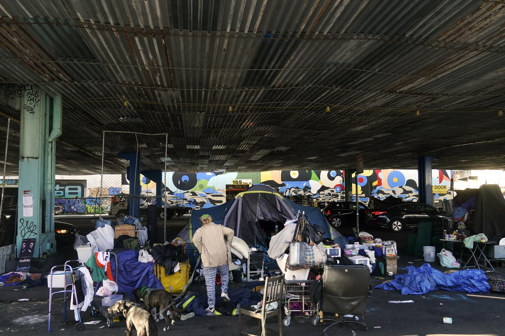 A woman gathers her possessions at a homeless encampment targeted for a sweep.   