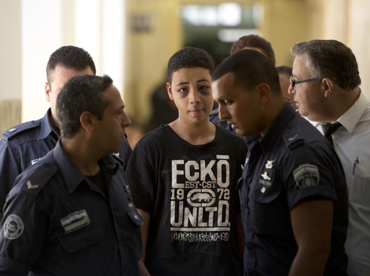 Tariq Abu Khdeir, 15, a U.S. citizen who relatives say was beaten and arrested by Israeli police during clashes sparked by the killing of his Palestiian cousin Mohammed Abu Khudair, 16, is escorted by Israeli prison guards during an appearance in a Jerusalem court on July 6.