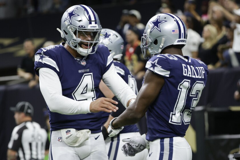 Dallas Cowboys quarterback Dak Prescott (4) celebrates the touchdown by Dallas Cowboys wide receiver Michael Gallup (13) during the first half of an NFL football game against the New Orleans Saints, Thursday, Dec. 2, 2021, in New Orleans. (AP Photo/Derick Hingle)