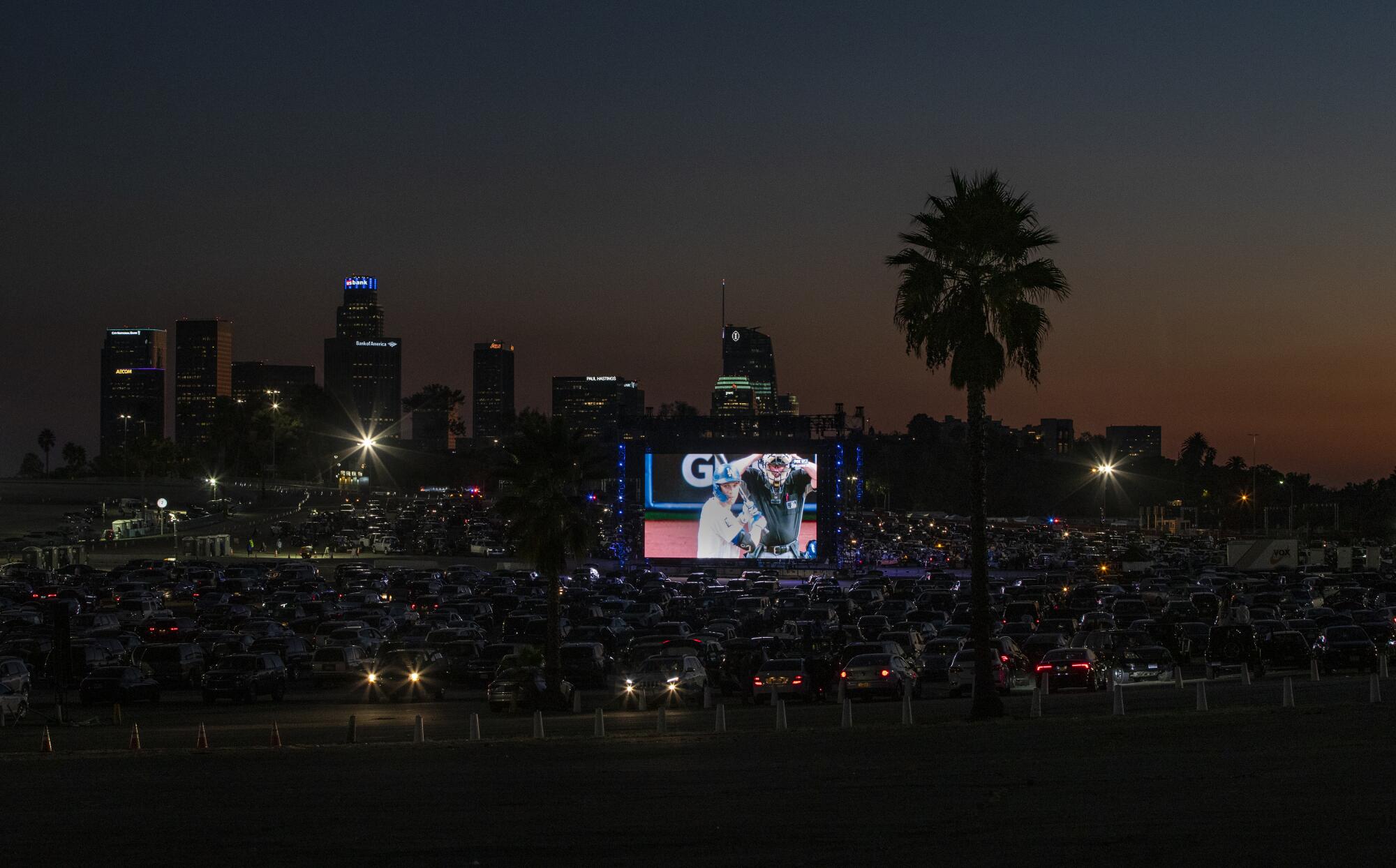 Dusks settles over the Dodger Stadium parking lot as fans watch Game 6 on the big screen.