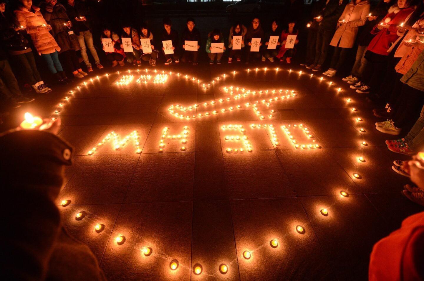 A picture made available on 15 March 2014 shows college students holding a candlelight vigil for the passengers on the missing Malaysia Airlines airliner MH370 in Yangzhou, Jiangsu province, China, on 13 March 2014.
