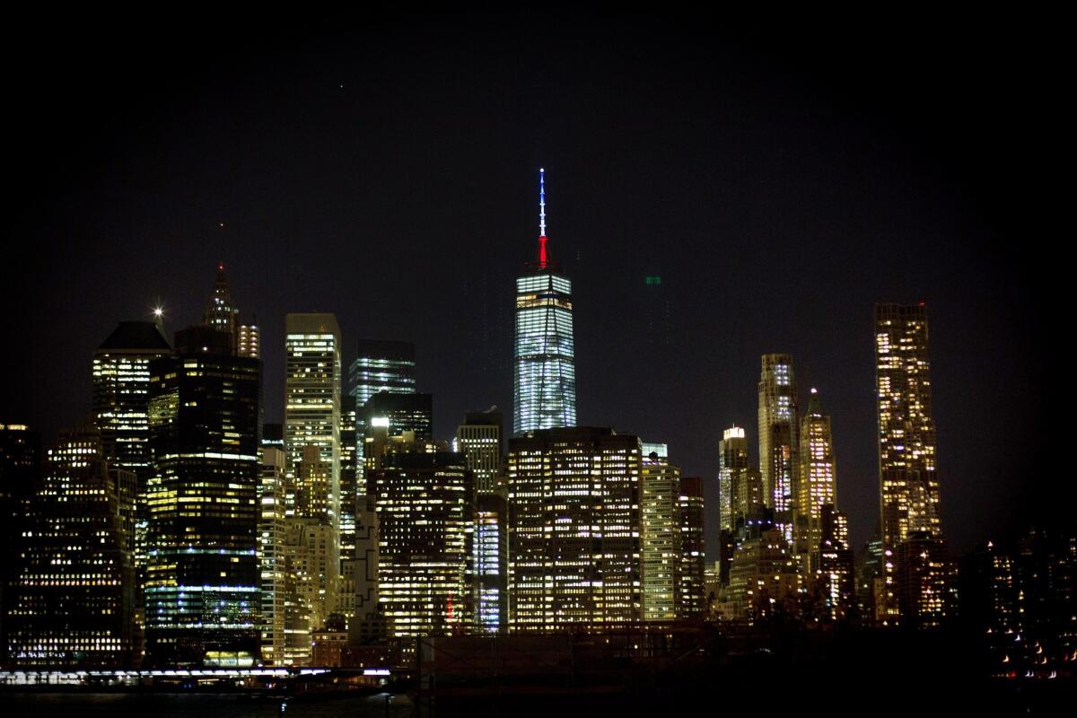 The One World Trade Center spire is lit blue, white and red after New York Gov. Andrew Cuomo announced the lighting in honor of dozens killed in the Paris attacks.