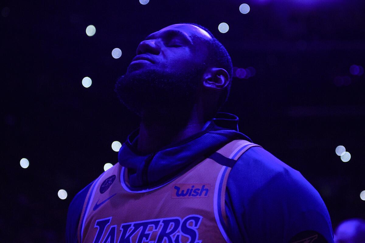 Los Angeles Lakers' LeBron James stands for a 24.2 second moment of silence for the late Kobe Bryant, prior the Lakers' NBA basketball game against the Portland Trail Blazers in Los Angeles, Friday, Jan. 31, 2020. (AP Photo/Kelvin Kuo)