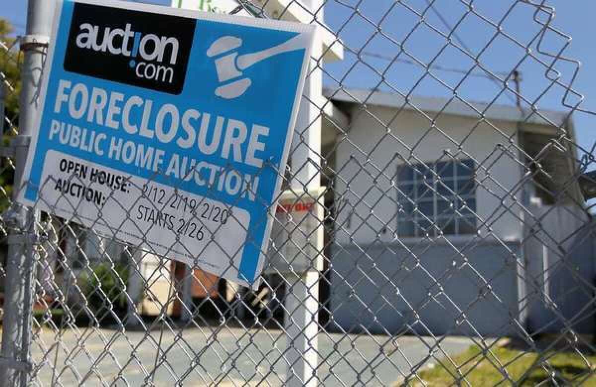 A foreclosure sign hangs on a fence in front of a home in Richmond, Calif., in 2011.