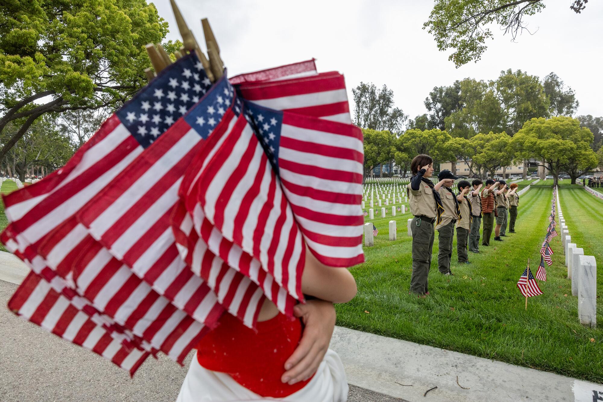 Boy Scout Troop 642 salutes for a troop group photo after helping plant flags at the Los Angeles National Cemetery.