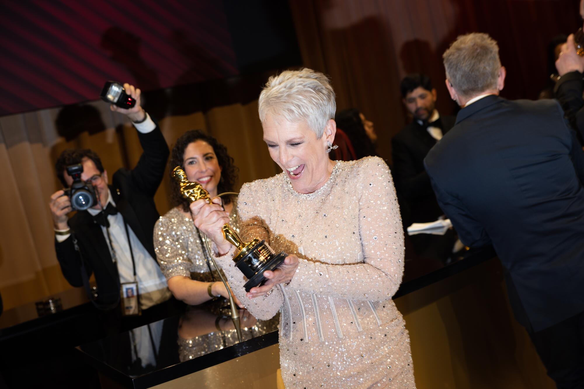 Jamie Lee Curtis smiles broadly at her just-engraved Oscar statuette.