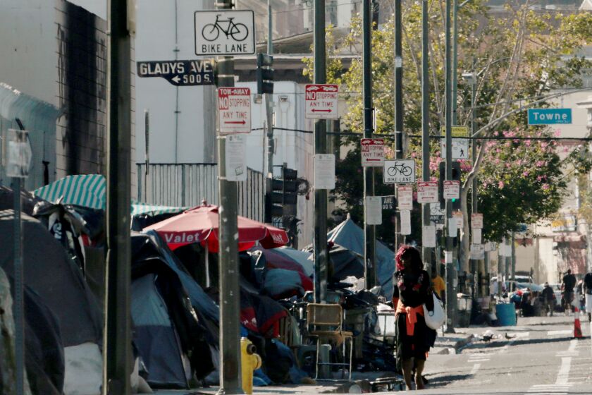 LOS ANGELES, CA - AUG. 11, 2020. Homeless encampments line the sidewalk along Fith Street in Los Angeles on Tuesday, Aug. 11, 2020. Many downtown stores and eateries remain shuttered or restricted because of coronavirus. Leases and rents are spiraling downward, and large numbers of homeless people live on the streets. (Luis Sinco/Los Angeles Times)
