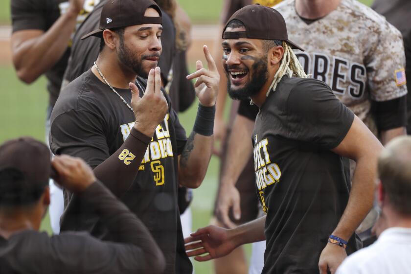 Tommy Pham and Fernando Tatis Jr. of the San Diego Padres celebrate after beating the Seattle Mariners and clinching a pla