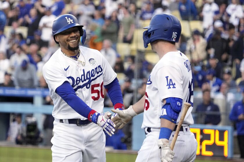 Los Angeles Dodgers' Mookie Betts, left, is congratulated by Will Smith after hitting a solo home run during the first inning of a baseball game against the New York Yankees Friday, June 2, 2023, in Los Angeles. (AP Photo/Mark J. Terrill)