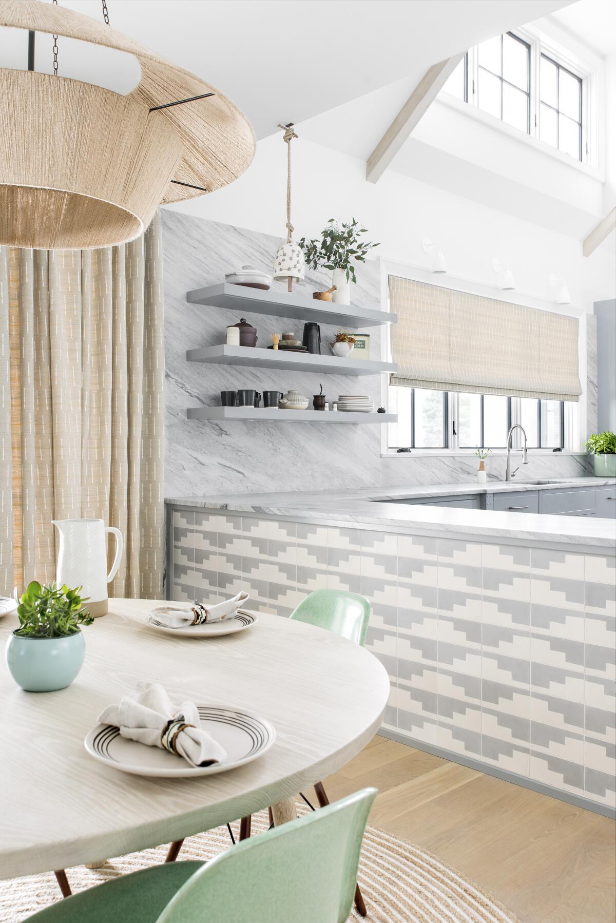 A brightly colored kitchen with distinctive patterned tiles on the island.