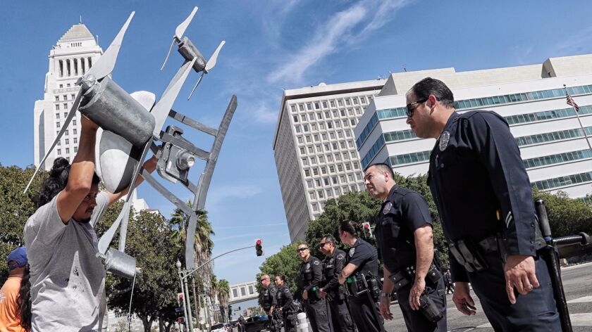 Miguel Guzman holds a replica drone in front of Los Angeles police officers after a group of drone opponents blocked traffic Tuesday in downtown L.A., protesting the L.A. Police Commission's vote to allow the LAPD to test drones during a handful of high-risk tactical situations.