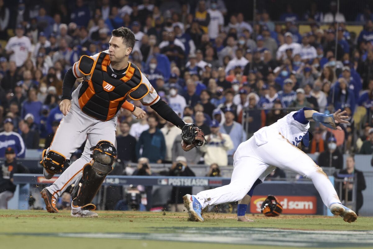 San Francisco Giants catcher Buster Posey tags out Dodgers' Gavin Lux at home.