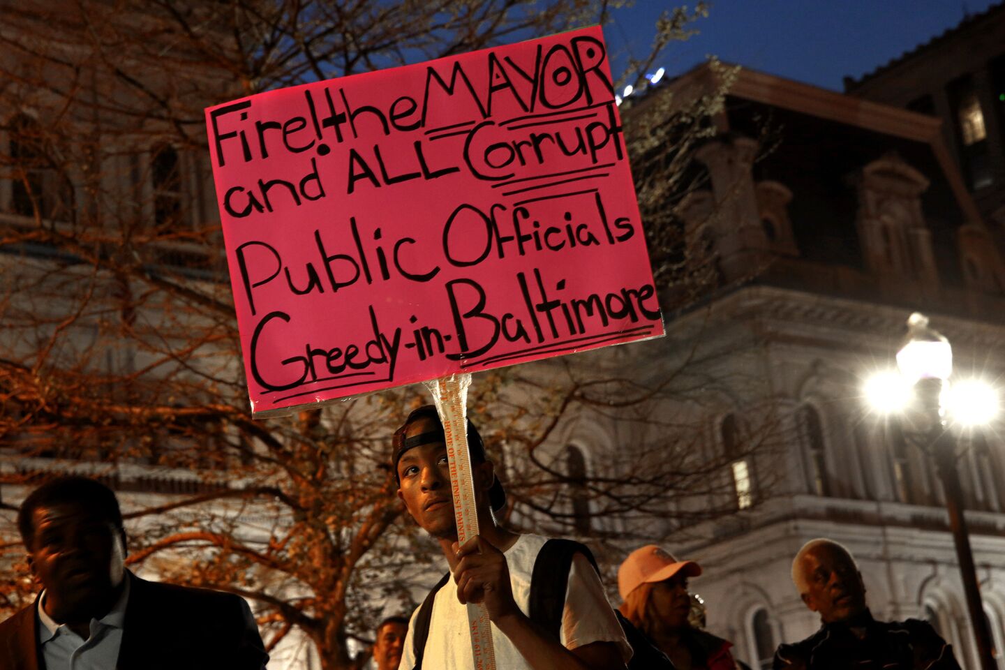 Outside Baltimore City Hall, protesters gather to denounce municipal officials.