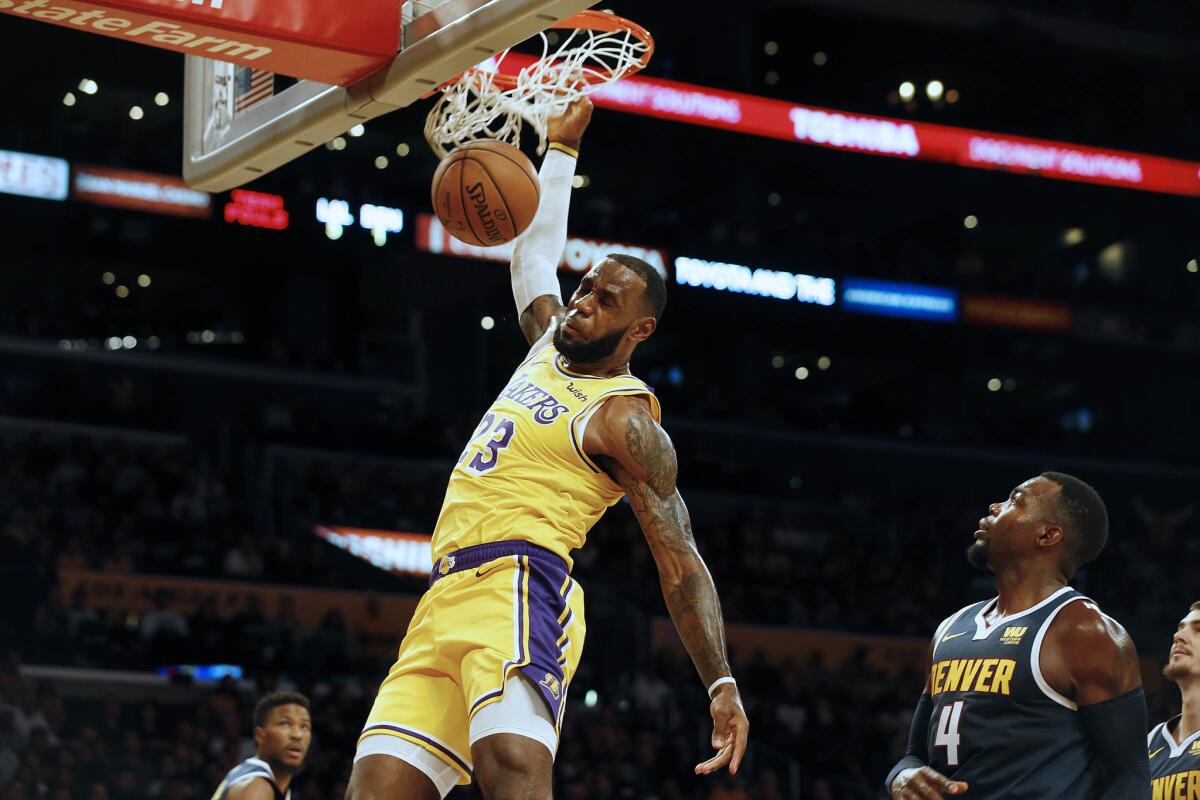 Lakers forward LeBron James throws down a dunk against the Nuggets during a preseason game Oct. 2 at Staples Center.