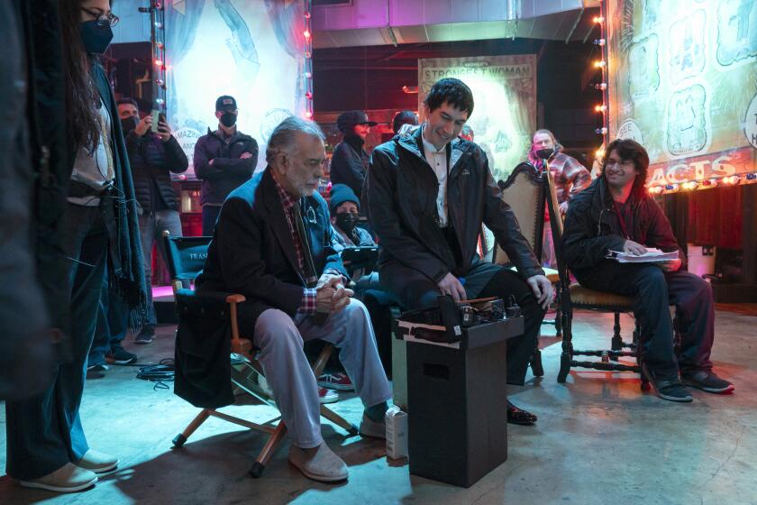 Francis Ford Coppola, left, and actor Adam Driver converse in adjacent chairs on the set of "Megalopolis" 