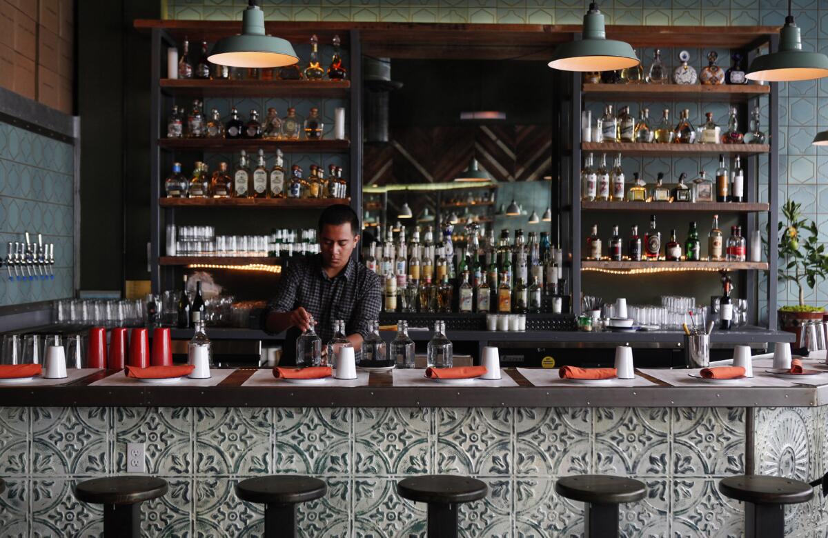 Juan Martinez, a bartender at Bar Ama, fills water pitchers at the Tex Mex restaurant downtown.