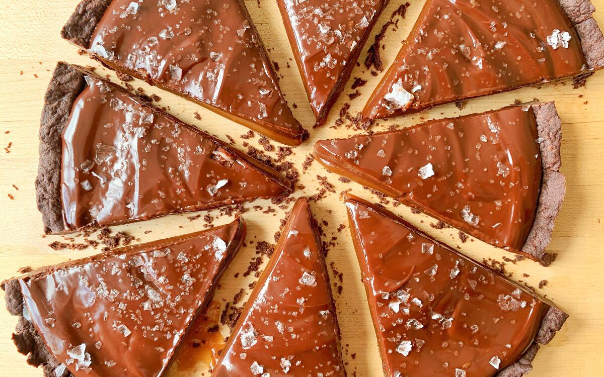 Salted caramel chocolate tart wedges, loosely arranged into a circle.