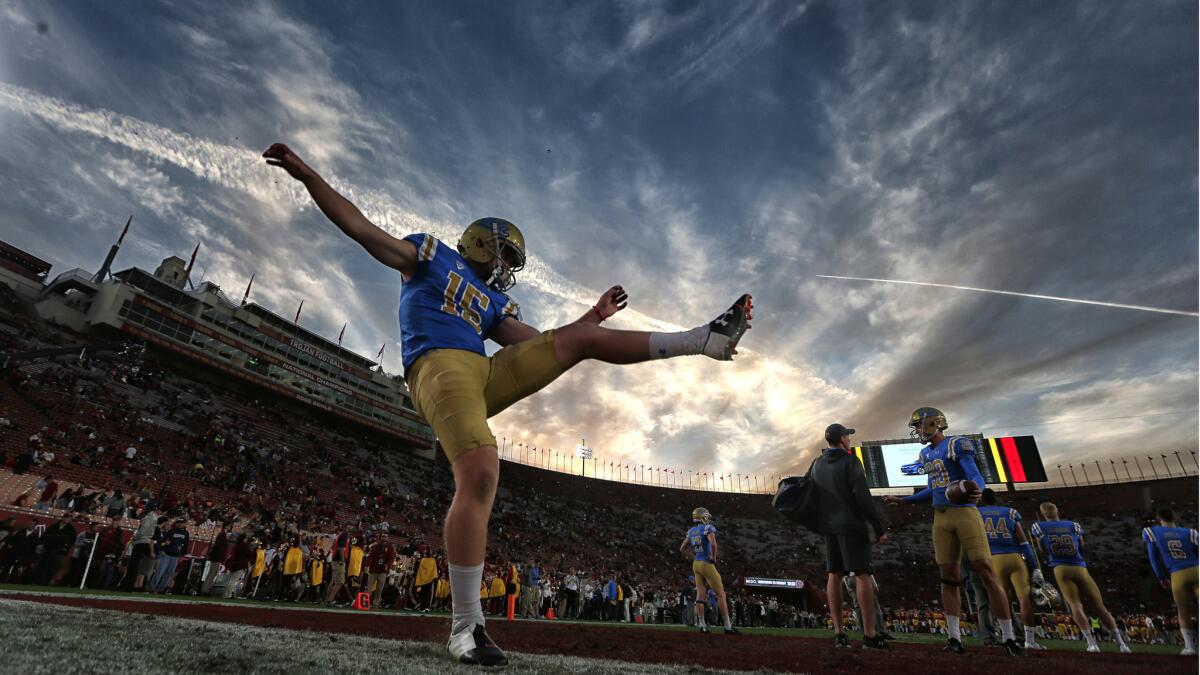 UCLA kicker Andrew Strauch warms up with the Bruins before game time against USC at the Coliseum.