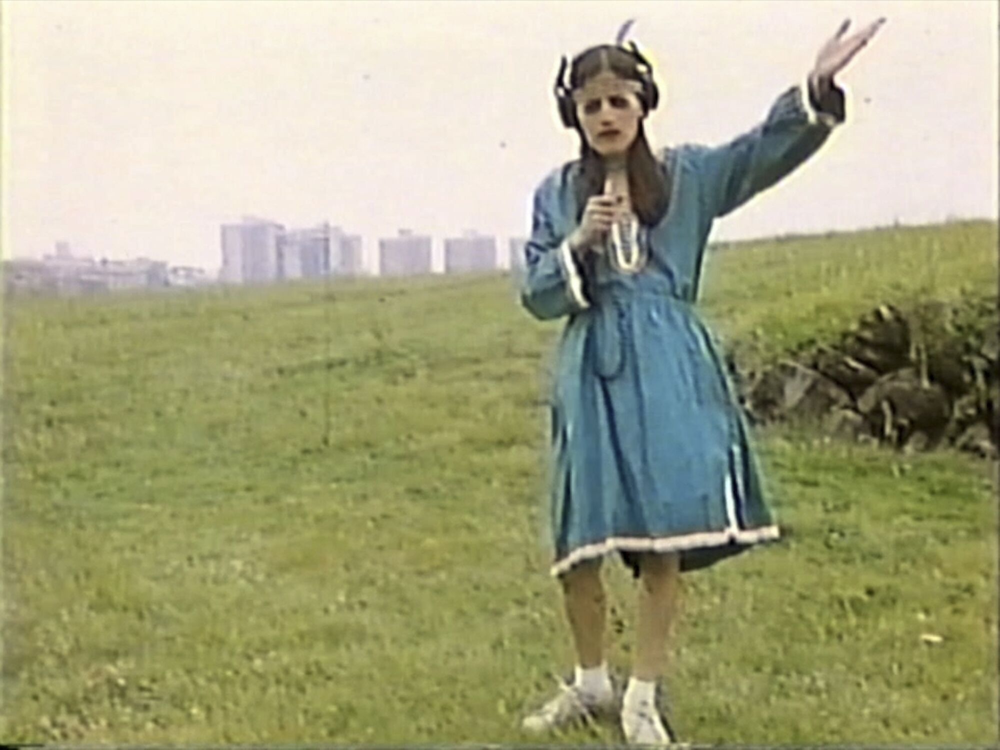 A video still shows Jesusa Rodriguez in a blue Indigenous dress acting as if she is broadcasting from a hillside