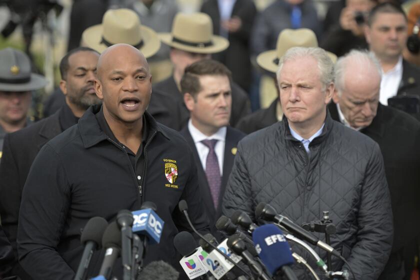 Maryland Gov. Wes Moore, left, speaks during a news conference as Sen. Chris Van Hollen (D-MD) looks on near the scene where a container ship collided with a support on the Francis Scott Key Bridge, Tuesday, March 26, 2024 in Baltimore. The major bridge in Baltimore snapped and collapsed after a container ship rammed into it early Tuesday, and several vehicles fell into the river below. Rescuers were searching for multiple people in the water. (AP Photo/Steve Ruark)