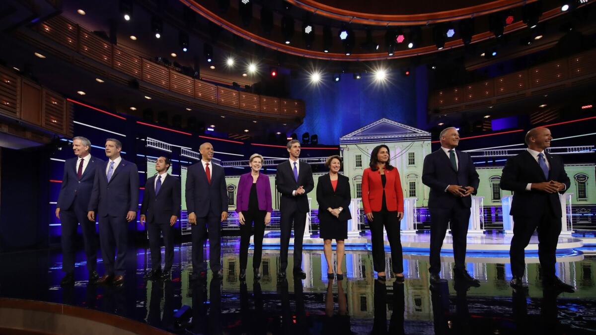 Democratic presidential candidates greet the debate audience in Miami on June 26.