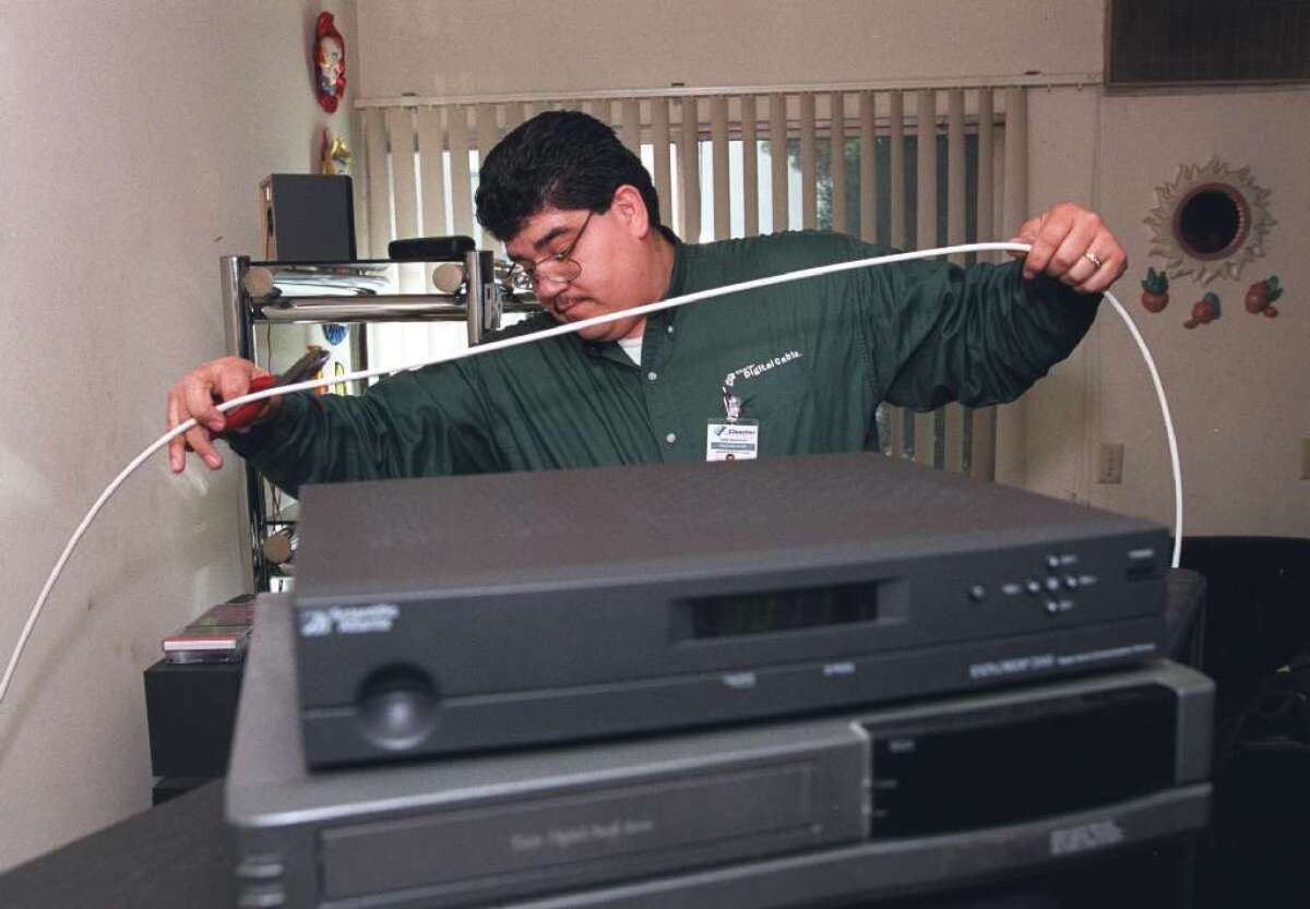 Cable companies such as Charter might be in trouble if a new report is any guide. Here, a Charter tech installs a box in 2000.