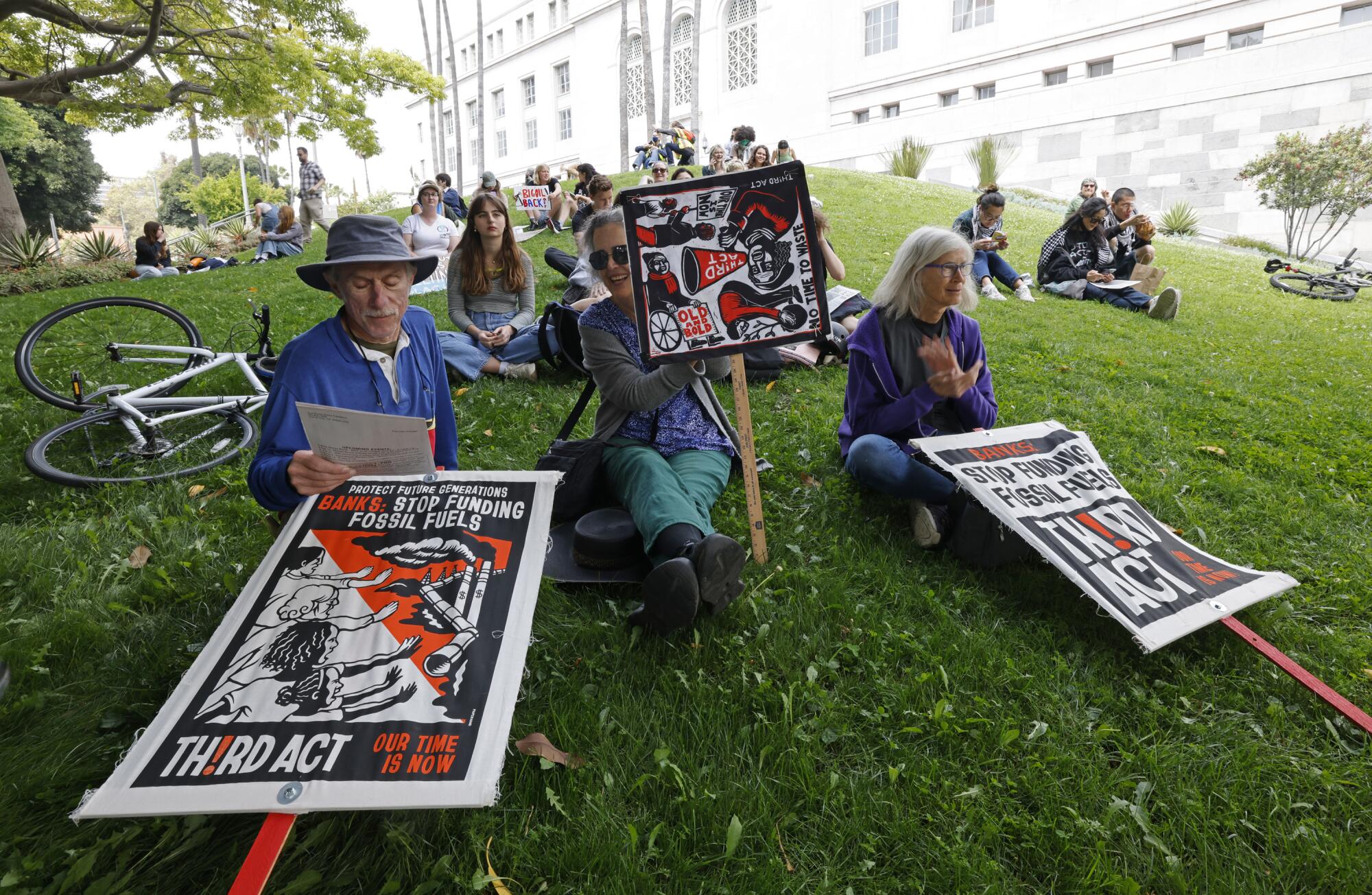  Senior activists sit on a grassy lawn.